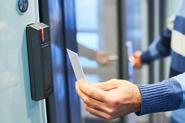 Person holding an RFID card to a black door reader