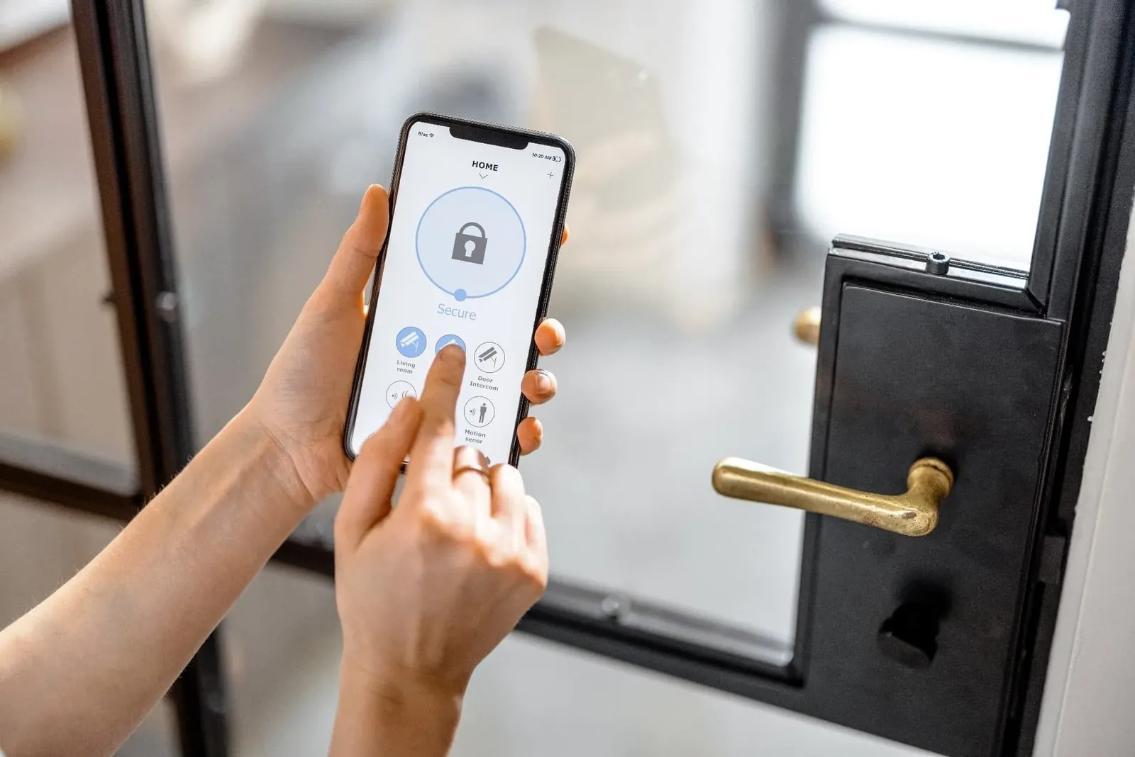 Person using a smartphone app to manage a smart lock beside a black door