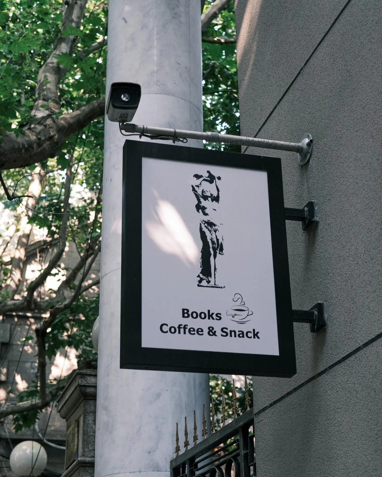 Camera above a cafe sign on a pole in Barrie