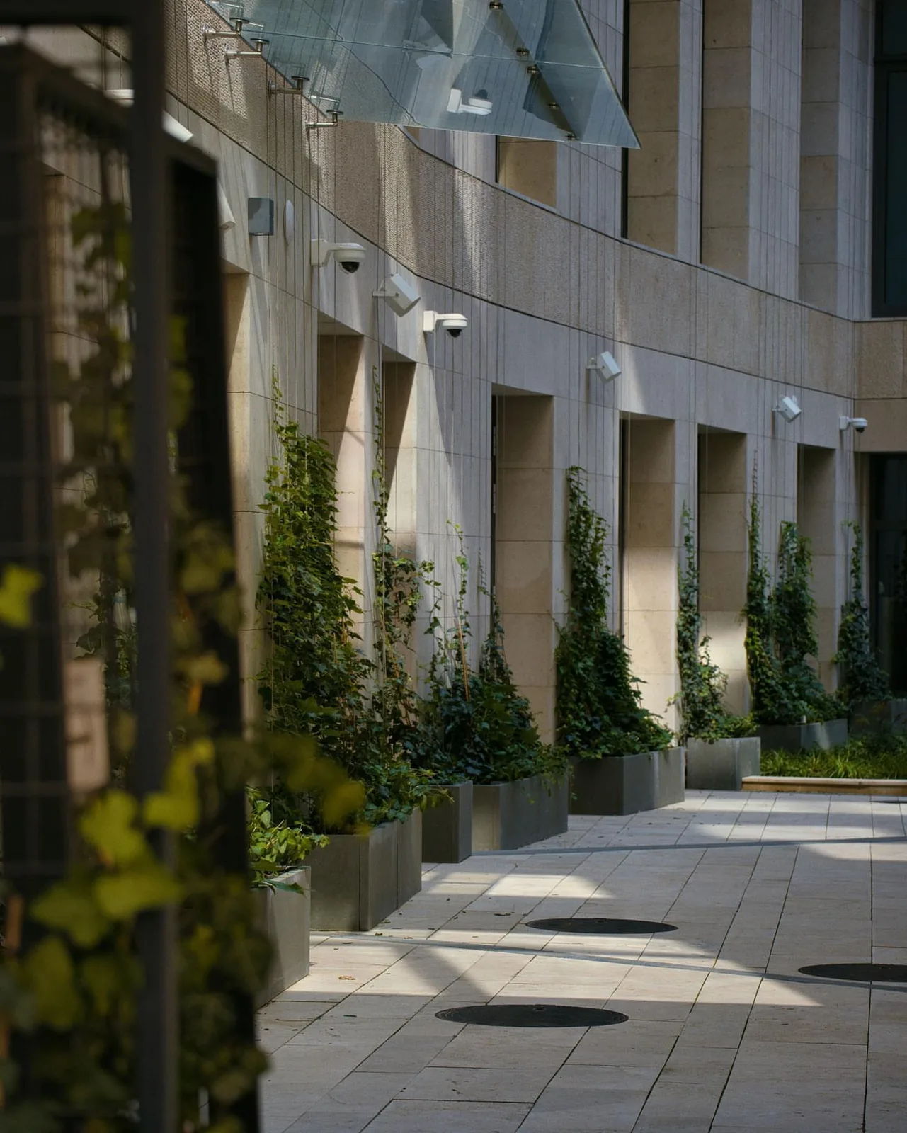 Cameras along a stone building facade with planters in Innisfil