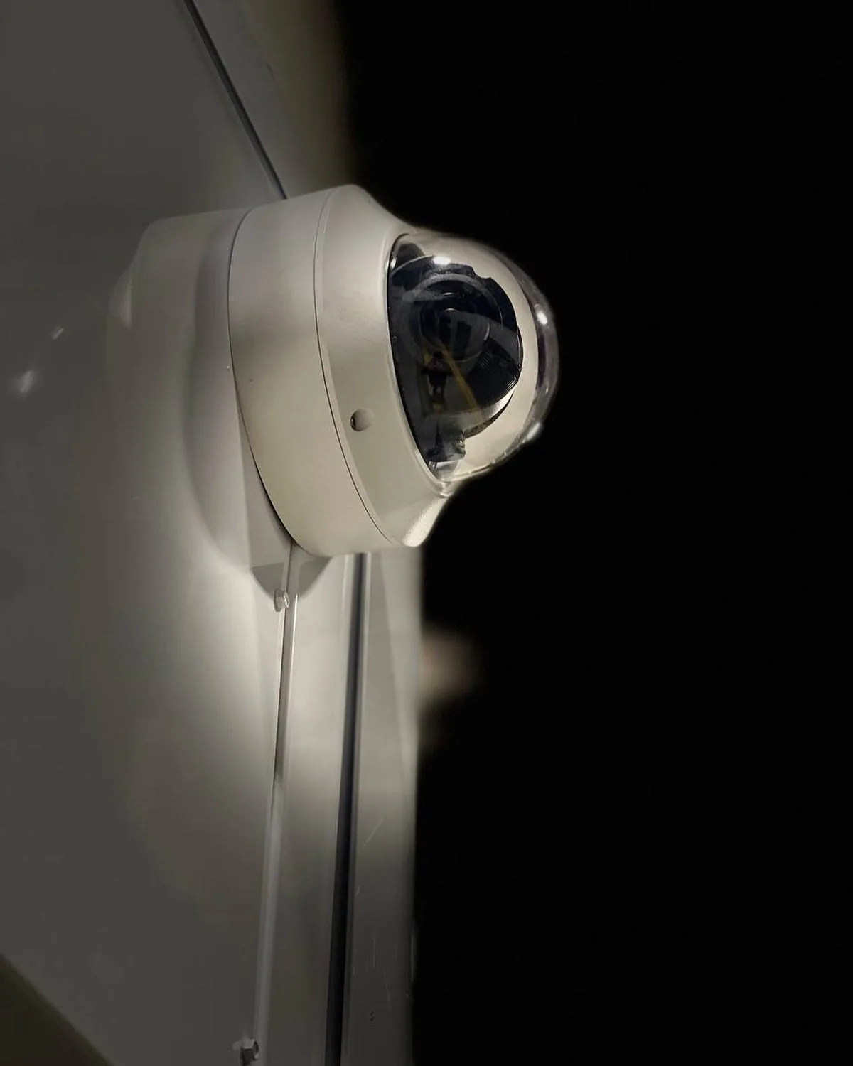 Dome camera under a soffit lit at night