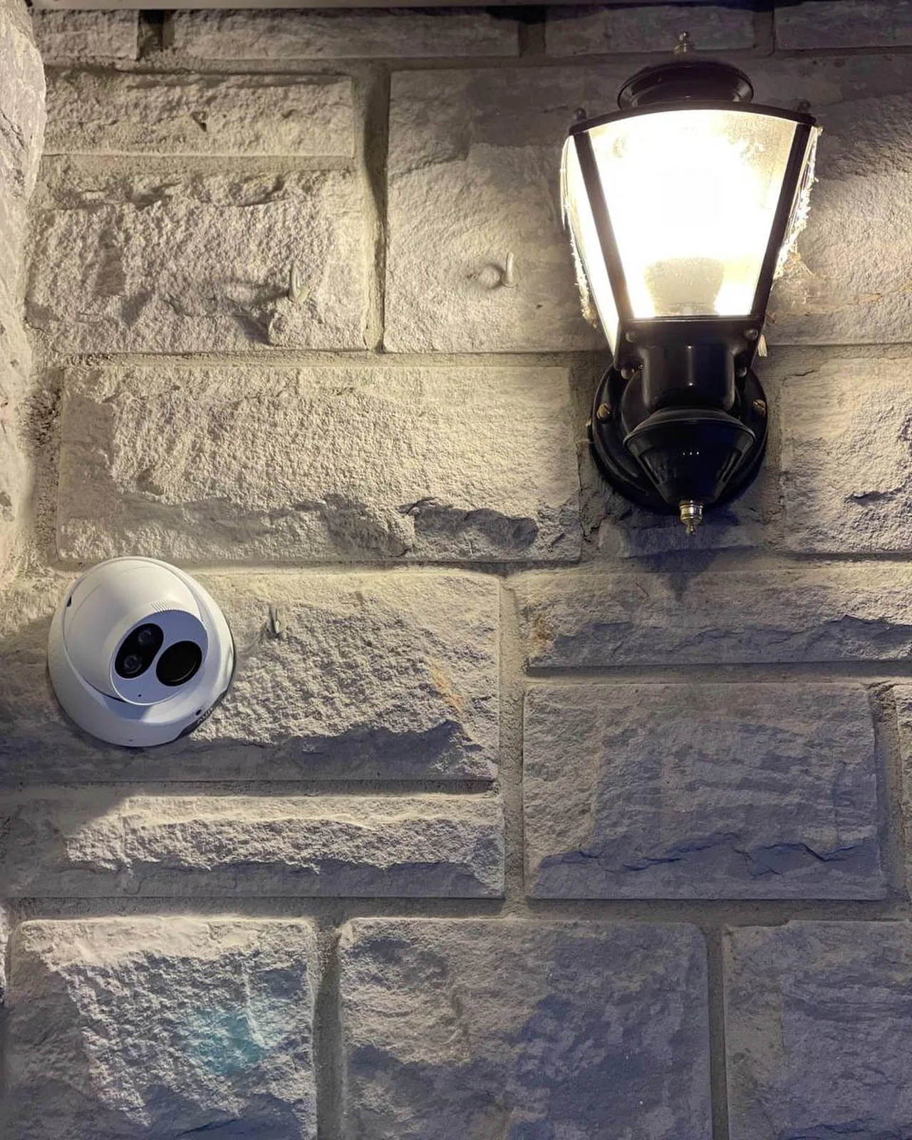 Turret camera below a lantern on a stone wall