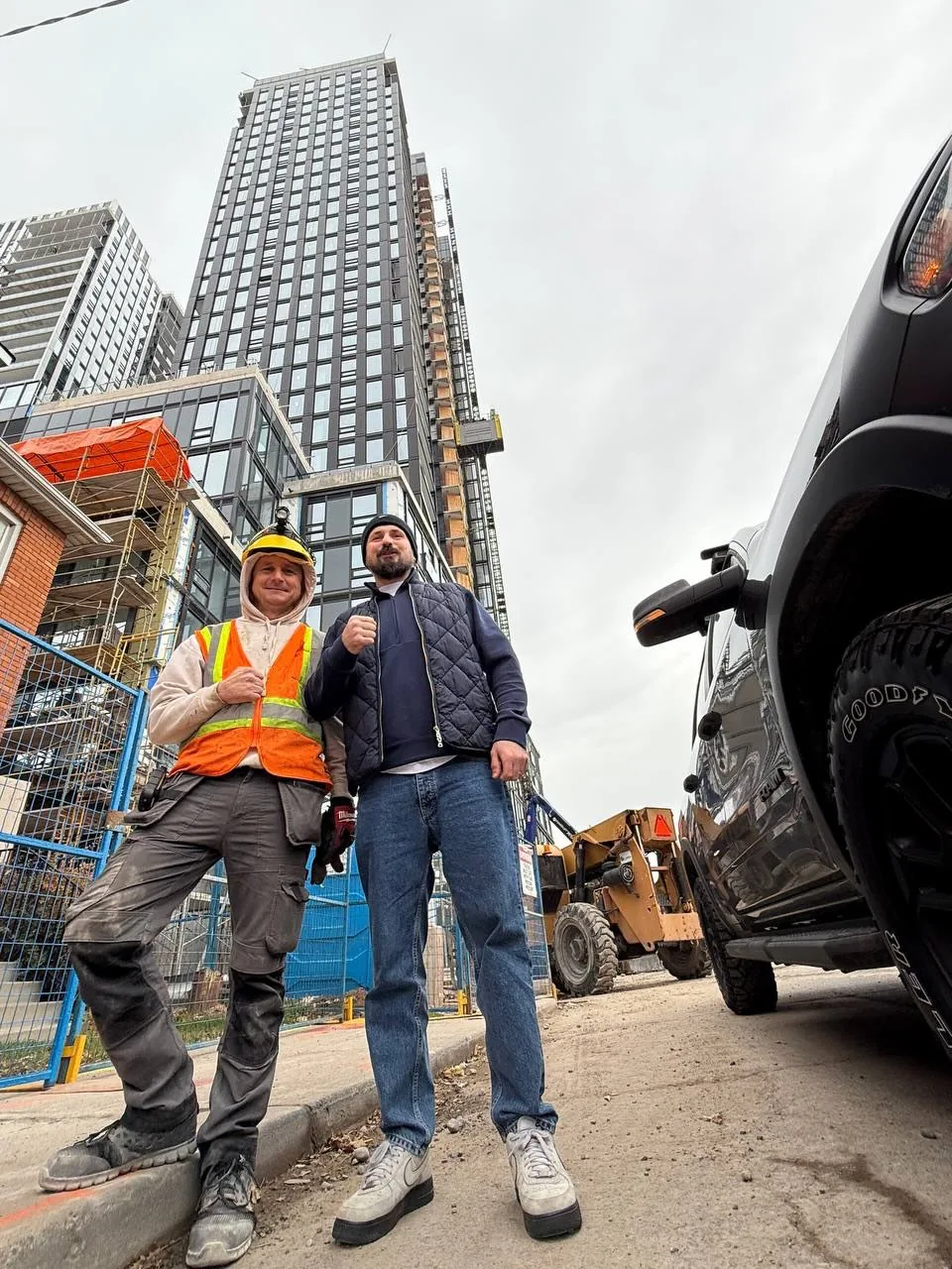 Two Sense Group technicians in front of a Toronto high-rise construction site