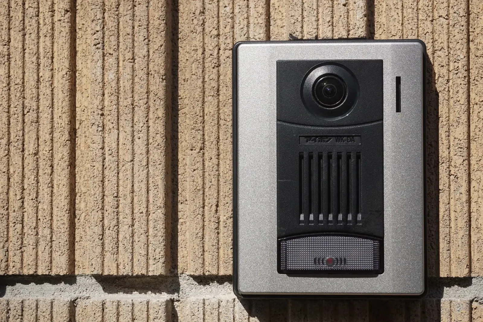 Stainless video intercom panel on a brick wall