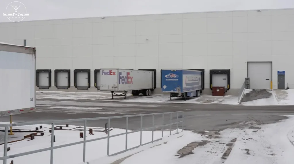 Commercial warehouse loading dock area in Ontario with delivery trailers during security camera installation project by Sense Group
