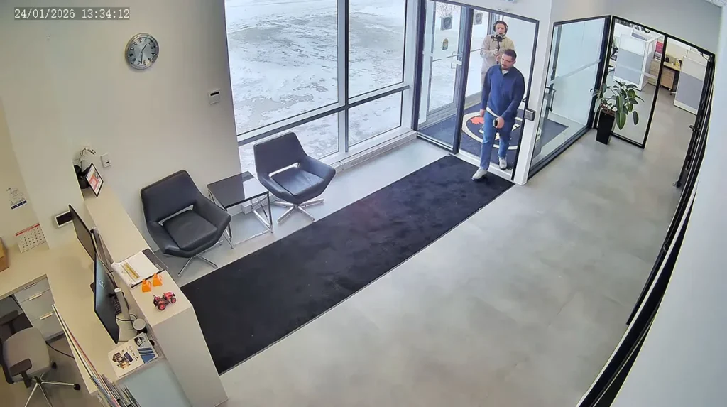 Security camera footage showing office lobby entrance with two people entering commercial building in Ontario